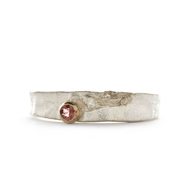 colored stone in gold detail on a silver ring