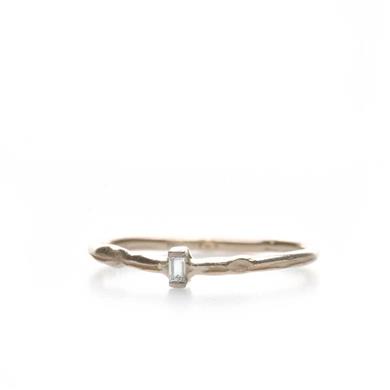Narrow golden ring with baguette diamond